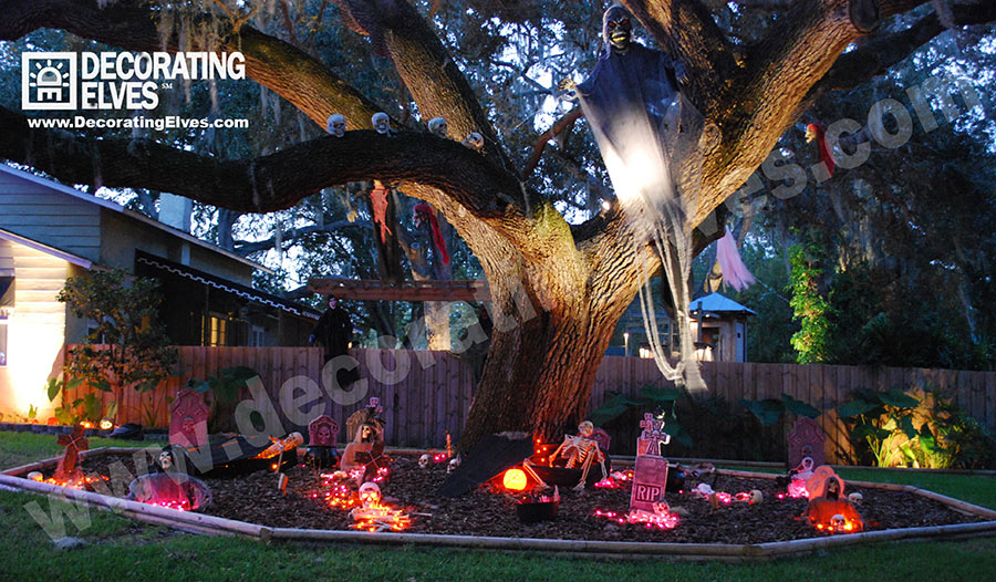 Graveyard Scene around Large Oak Tree with Hanging Ghost and skulls on a limb www.decoratingelves.com
