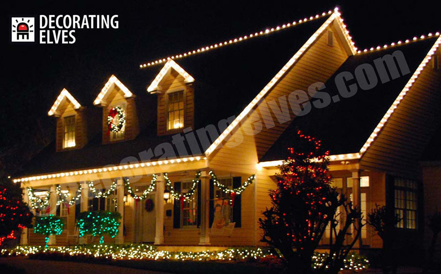 Residental-Holiday-Home-Roof-outlined,-minis-through-out-bushes-and-beds,-garland-swags-wreath,-www.decoratingelves.com