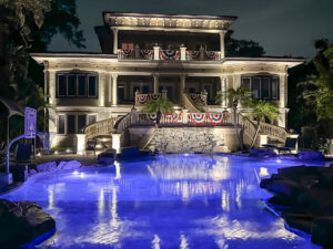 luxury home with beautifully lit pool area in the summertime 