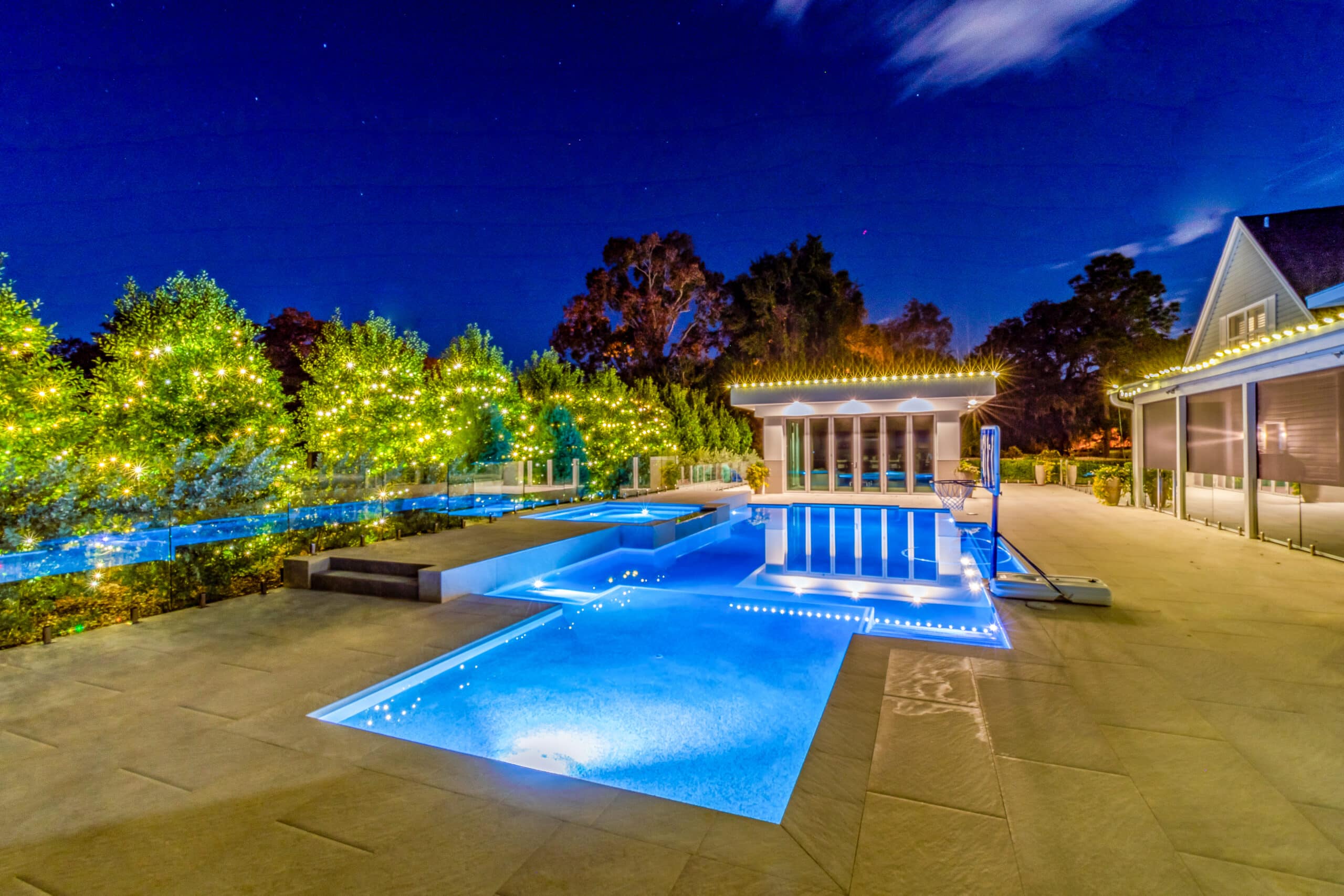 Warm-white-LED-in-trees-around-pool-roofline-www.decoratingelves.com