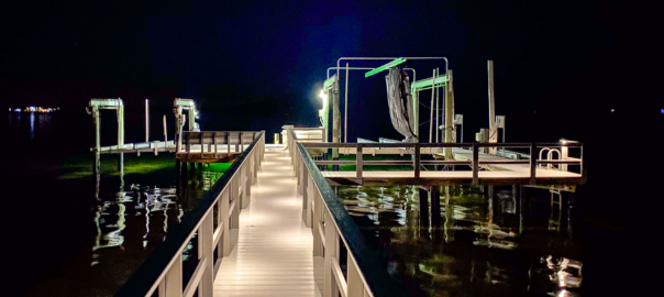 Long beautifully lit dock to boat deck